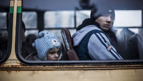 A Ukrainian youth and a Ukrainian young boy sit in a bus before fleeing Debaltseve, in the Donetsk region, on February 3, 2015. - Sputnik Afrique