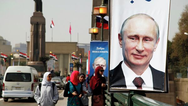 Girls walk past a banner with a picture of Russian President Vladimir Putin along a bridge, in central Cairo February 9, 2015. - Sputnik Afrique