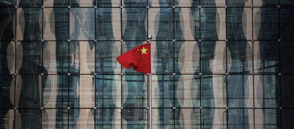 A Chinese national flag flutters at the headquarters of a commercial bank on a financial street near the headquarters of the People's Bank of China, China's central bank, in central Beijing in this November 24, 2014 file photo. - Sputnik Afrique