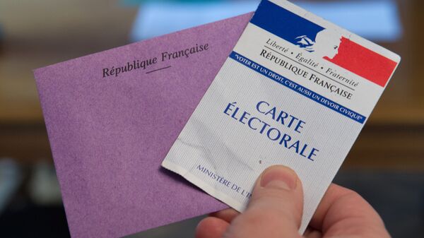 A man holds his electoral card and a ballot as he votes in the second round of the legislative by-election in the 4th constituency of the Doubs in Pont-de-Roide on February 8, 2015.  - Sputnik Afrique