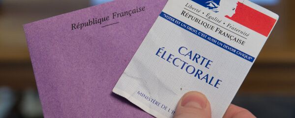 A man holds his electoral card and a ballot as he votes in the second round of the legislative by-election in the 4th constituency of the Doubs in Pont-de-Roide on February 8, 2015. - Sputnik Afrique