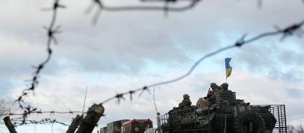 A Ukrainian military convoy is pictured through a barbed wire fence at a military base in the town of Kramatorsk, eastern Ukraine - Sputnik Afrique