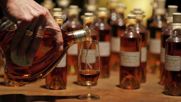 A technical expert tastes cognac in the cellar where Oak barrels are stored at the distillery of Courvoisier house in Cognac, southwestern France, February 11, 2015 - Sputnik Afrique