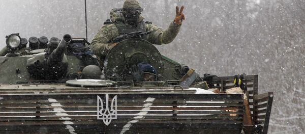 An Ukrainian soldier strikes a V-Victory sign driving on his vehicle on the road between the towns of Debaltseve and Artemivsk, Ukraine, Monday, Feb. 16, 2015. - Sputnik Afrique