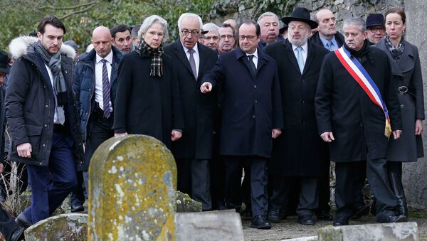 French President Francois Hollande (C), Israeli ambassador to France Yossi Gal (4thL), Strasbourg and Bas-Rhin Grand Rabbi Rene Gutman (3rdR) and Sarre-Union Mayor Marc Sene (2ndR) walk past desecrated tombstones during a visit at the Sarre-Union Jewish cemetery, eastern France, February 17, 2015. - Sputnik Afrique