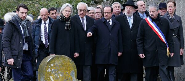 French President Francois Hollande (C), Israeli ambassador to France Yossi Gal (4thL), Strasbourg and Bas-Rhin Grand Rabbi Rene Gutman (3rdR) and Sarre-Union Mayor Marc Sene (2ndR) walk past desecrated tombstones during a visit at the Sarre-Union Jewish cemetery, eastern France, February 17, 2015. - Sputnik Afrique