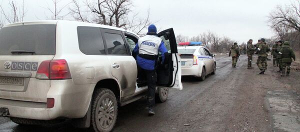 Автомобили ОБСЕ и полиции, которые сопровождают колонну автобусов, прибывших в Дебальцево - Sputnik Afrique