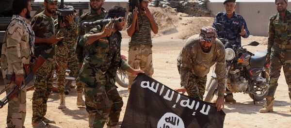 Iraqi security forces hold a flag of the Islamic State group they captured during an operation outside Amirli, some 105 miles (170 kilometers) north of Baghdad, Iraq - Sputnik Afrique