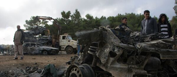 People stand around the wreckage of a vehicle near the site of a bomb blast in Shahat, eastern Libya, November 9, 2014 - Sputnik Afrique