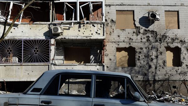 A man drives a car in front of a damaged building in Donetsk, on February 12, 2015 - Sputnik Afrique