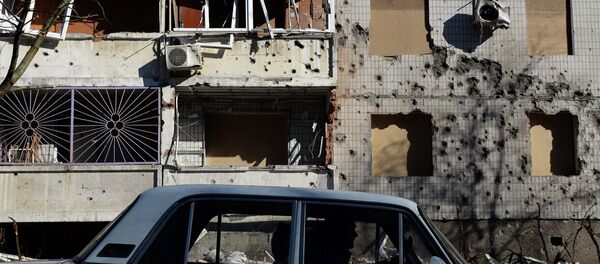 A man drives a car in front of a damaged building in Donetsk, on February 12, 2015 - Sputnik Afrique