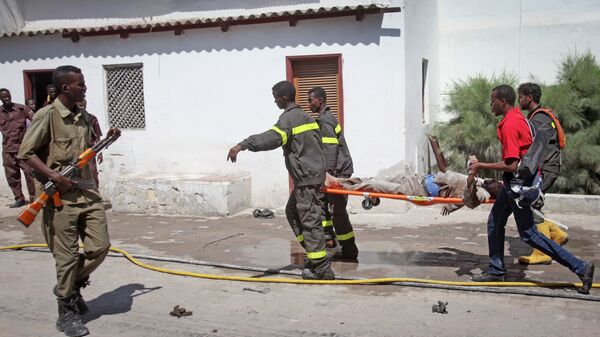 Des sauveteurs somaliens emportent le corps d'une victime d'un attentat à Mogadiscio - Sputnik Afrique