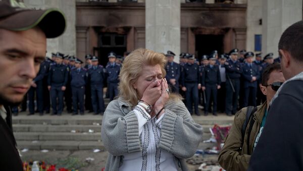 A woman cries back dropped by police troops guarding the burnt trade union building in Odessa, Ukraine, Saturday, May 3, 2014 - Sputnik Afrique