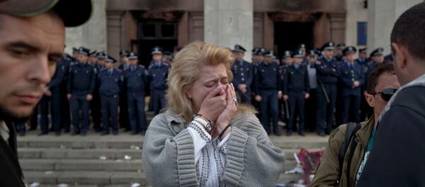 A woman cries back dropped by police troops guarding the burnt trade union building in Odessa, Ukraine, Saturday, May 3, 2014 - Sputnik Afrique