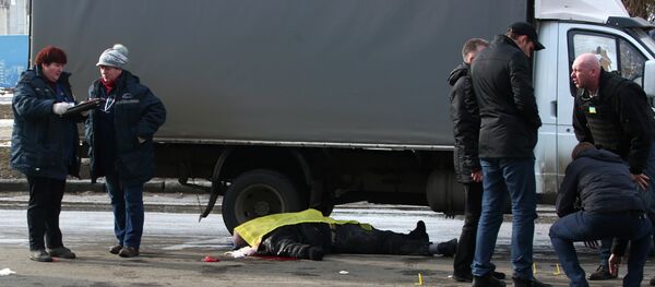 Forensic experts work at a site of an explosion, as a body of a victim is covered with a Ukrainian flag in Kharkiv - Sputnik Afrique