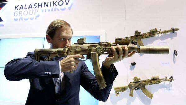 Russian Industry and Trade Minister Denis Manturov aims a weapon during the International Defence Exhibition (IDEX) in Abu Dhabi February 22, 2015 - Sputnik Afrique