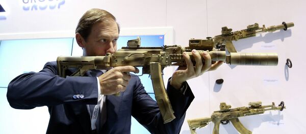 Russian Industry and Trade Minister Denis Manturov aims a weapon during the International Defence Exhibition (IDEX) in Abu Dhabi February 22, 2015 - Sputnik Afrique