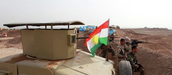 A Kurdish flag is seen next to Peshmerga fighters taking position with their weapons on the frontline against the Islamic State, on the outskirts of Mosul January 26, 2015. - Sputnik Afrique