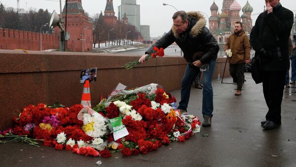 People come to lay flowers at the site, where Boris Nemtsov was shot dead, with St. Basil's Cathedral (R) and the Kremlin walls seen in the background, in central Moscow, February 28, 2015. - Sputnik Afrique