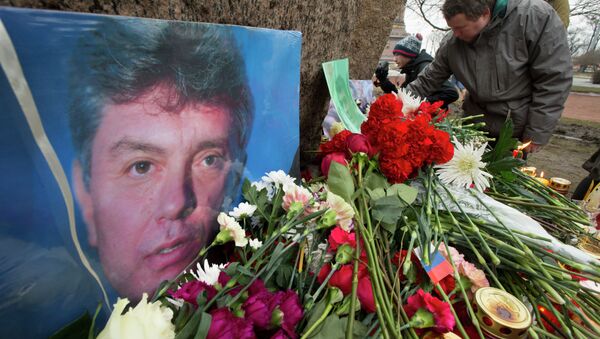 People lay flowers in memory of Boris Nemtsov, seen at left, at the monument of political prisoners 'Solovetsky Stone' in central St. Petersburg, Russia, Saturday, Feb. 28, 2015. - Sputnik Afrique