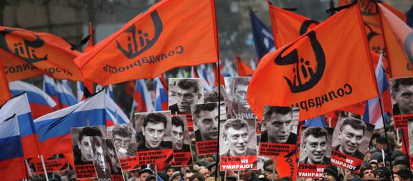 People march in memory of opposition leader Boris Nemtsov, who was gunned down on Friday, Feb. 27, 2015, near the Kremlin with portraits of him and words reading ' those bullets for everyone of us, heroes never die! in Moscow, Russia, Sunday, March 1, 2015. - Sputnik Afrique