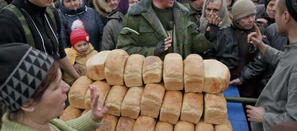 A man speaks to a crowd of residents warning them not to push as they wait to get bread, one per person, baked by Russia-backed separatists in Chornukhyne, Ukraine, Monday, March 2, 2015 - Sputnik Afrique