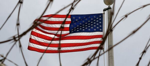 An American Flag is seen through razor wire at Camp VI in Camp Delta where detainees are housed at Naval Station Guantanamo Bay in Cuba - Sputnik Afrique
