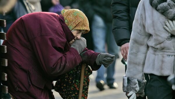 A pensioner begs for money as pedestrians pass by in central Kiev, Ukraine - Sputnik Afrique