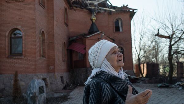 A woman reacts as she looks at a damaged church in Donetsk's Oktyabrski district, March 9, 2015 - Sputnik Afrique