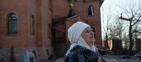 A woman reacts as she looks at a damaged church in Donetsk's Oktyabrski district, March 9, 2015 - Sputnik Afrique