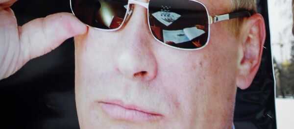 An activist holds a poster with a photo of Russia's President Vladimir Putin during a rally in his support in Stavropol February 21, 2015 - Sputnik Afrique