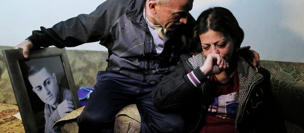 The mother and father of Muhammad Musallam, an Israeli Arab held by Islamic State in Syria as an alleged spy, react beside a picture of him in their East Jerusalem home March 10, 2015. - Sputnik Afrique