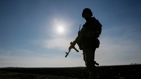 A member of the Ukrainian armed forces is silhouetted as he stands at his position near Kramatorsk, March 11, 2015 - Sputnik Afrique