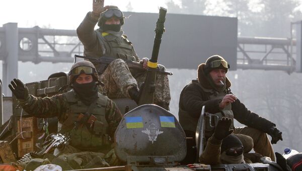 Ukrainian servicemen ride atop an armoured personnel carrier (APC), as they return from the frontline in eastern Ukraine, in Kiev March 11, 2015 - Sputnik Afrique
