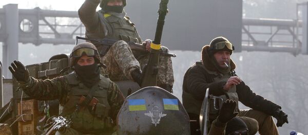 Ukrainian servicemen ride atop an armoured personnel carrier (APC), as they return from the frontline in eastern Ukraine, in Kiev March 11, 2015 - Sputnik Afrique