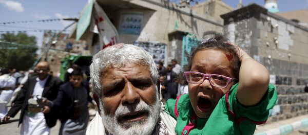 An injured girl reacts as she is carried by a man out of a mosque which was attacked by a suicide bomber in Sanaa March 20, 2015. - Sputnik Afrique