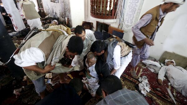 People help an injured man at the scene of a suicide bombing inside a mosque in Sanaa March 20, 2015 - Sputnik Afrique