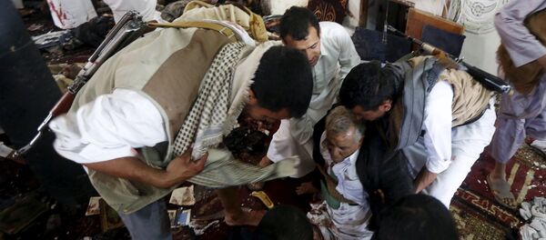 People help an injured man at the scene of a suicide bombing inside a mosque in Sanaa March 20, 2015 - Sputnik Afrique