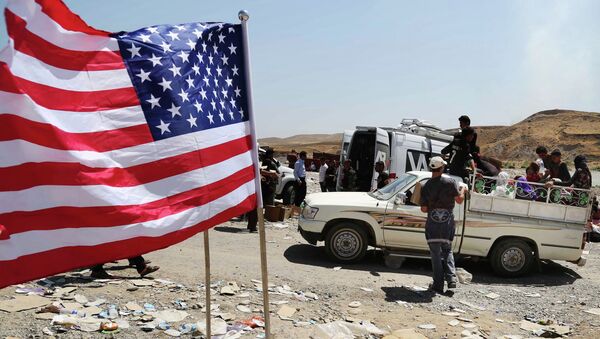 US flag waves while displaced Iraqis from the Yazidi community cross the Syria-Iraq border on Feeshkhabour bridge over Tigris River at Feeshkhabour border point, northern Iraq - Sputnik Afrique