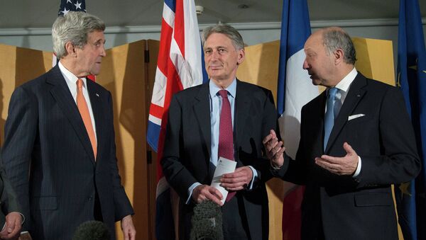 US Secretary of State John Kerry (L), British Foreign Secretary Philip Hammond (C) and French Foreign Minister Laurent Fabius (L) talk after Secretary Hammond made a statement about their meeting regarding recent negotiations with Iran over Iran's nuclear program - Sputnik Afrique