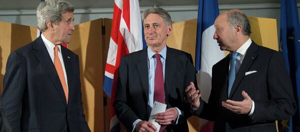 US Secretary of State John Kerry (L), British Foreign Secretary Philip Hammond (C) and French Foreign Minister Laurent Fabius (L) talk after Secretary Hammond made a statement about their meeting regarding recent negotiations with Iran over Iran's nuclear program - Sputnik Afrique