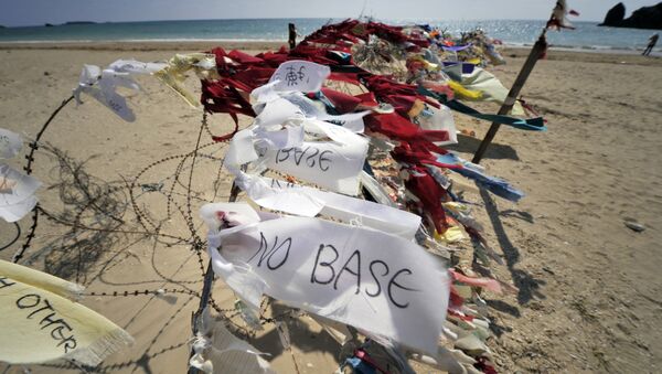 This picture taken on November 7, 2009 shows ribbon-messages saying no base against the US bases on the island, tied to a barbed wire barricade near the US military base Camp Schwab in Henoko on the eastern coast of Okinawa - Sputnik Afrique