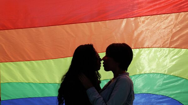 A gay couple embraces as they stand in front of a rainbow flag during a protest outside the town hall in Monterrey March 4, 2015 - Sputnik Afrique