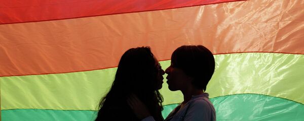 A gay couple embraces as they stand in front of a rainbow flag during a protest outside the town hall in Monterrey March 4, 2015 - Sputnik Afrique