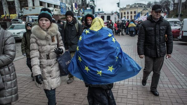 Женщина, обернувшаяся во флаг ЕС, идет по Крещатику в Киеве. - Sputnik Afrique