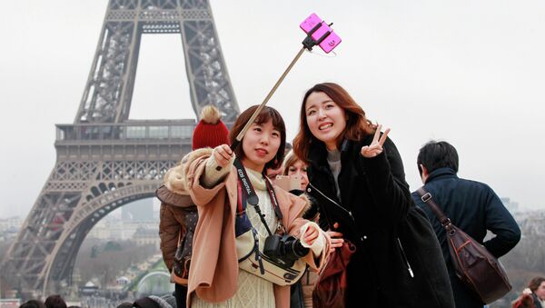 Des touristes avec une perche à selfie, à Paris - Sputnik Afrique