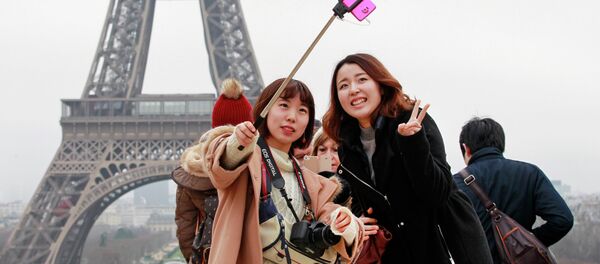 Des touristes avec une perche à selfie, à Paris - Sputnik Afrique