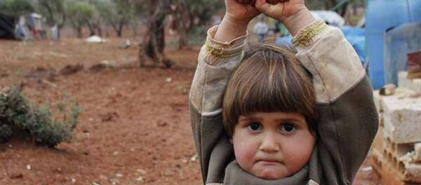 Little Adi Hudea raises her hands in surrender after confusing photographer Osman Sagirli's camera for a gun - Sputnik Afrique