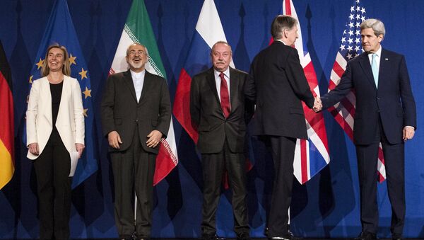 (L-R) European Union High Representative for Foreign Affairs and Security Policy Federica Mogherini, Iranian Foreign Minister Javad Zarifat and an unidentified Russian official look on as British Foreign Secretary Philip Hammond shakes hands with U.S. Secretary of State John Kerry, following nuclear talks at the Swiss Federal Institute of Technology in Lausanne - Sputnik Afrique