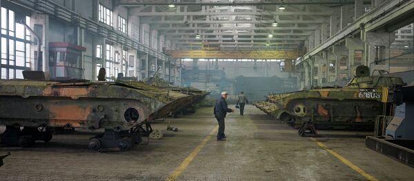 Employees work on armoured vehicles at an armor repair plant on September 23, 2014 in Zhytomyr, some 150kms west of Kiev - Sputnik Afrique